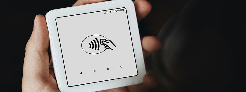 Hand holding mobile device with contactless payment